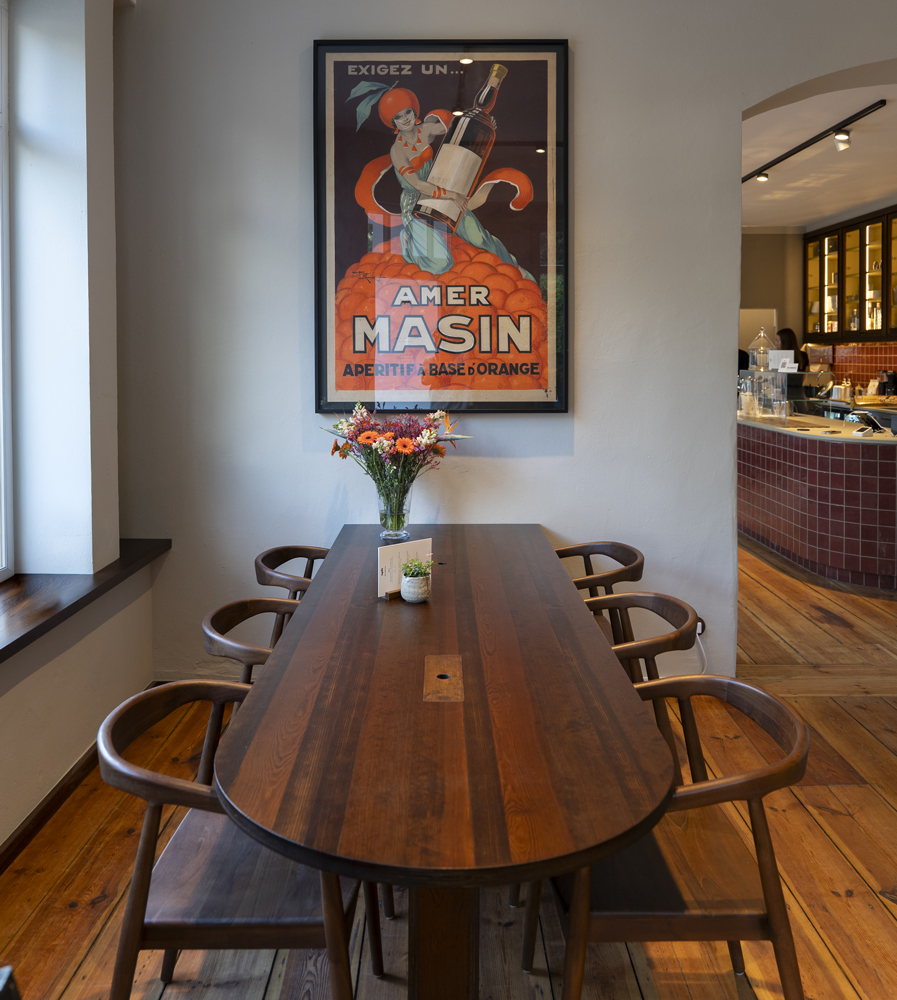 foto aus dem eingangsbereich des cafes nyde. ein tisch und ein bild